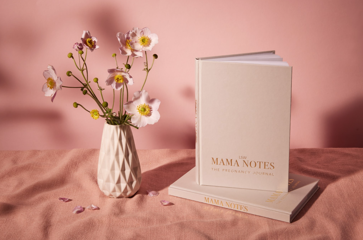 Book titled 'MAMA NOTES' with a vase of flowers on a pink background