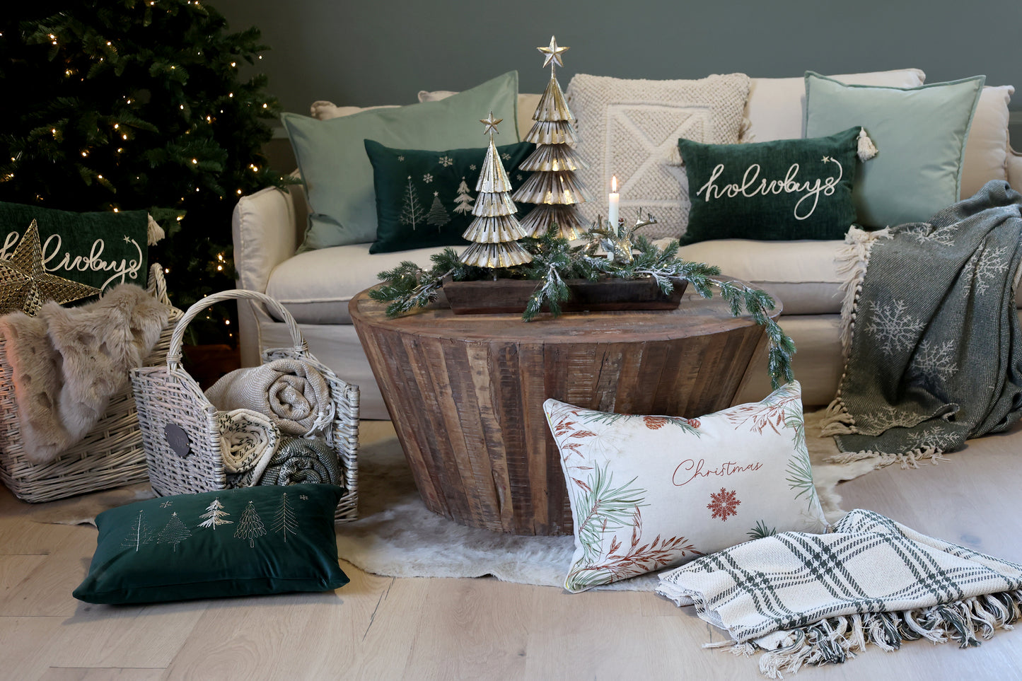 Living room with Christmas decorations including a tree, pillows, and a coffee table.