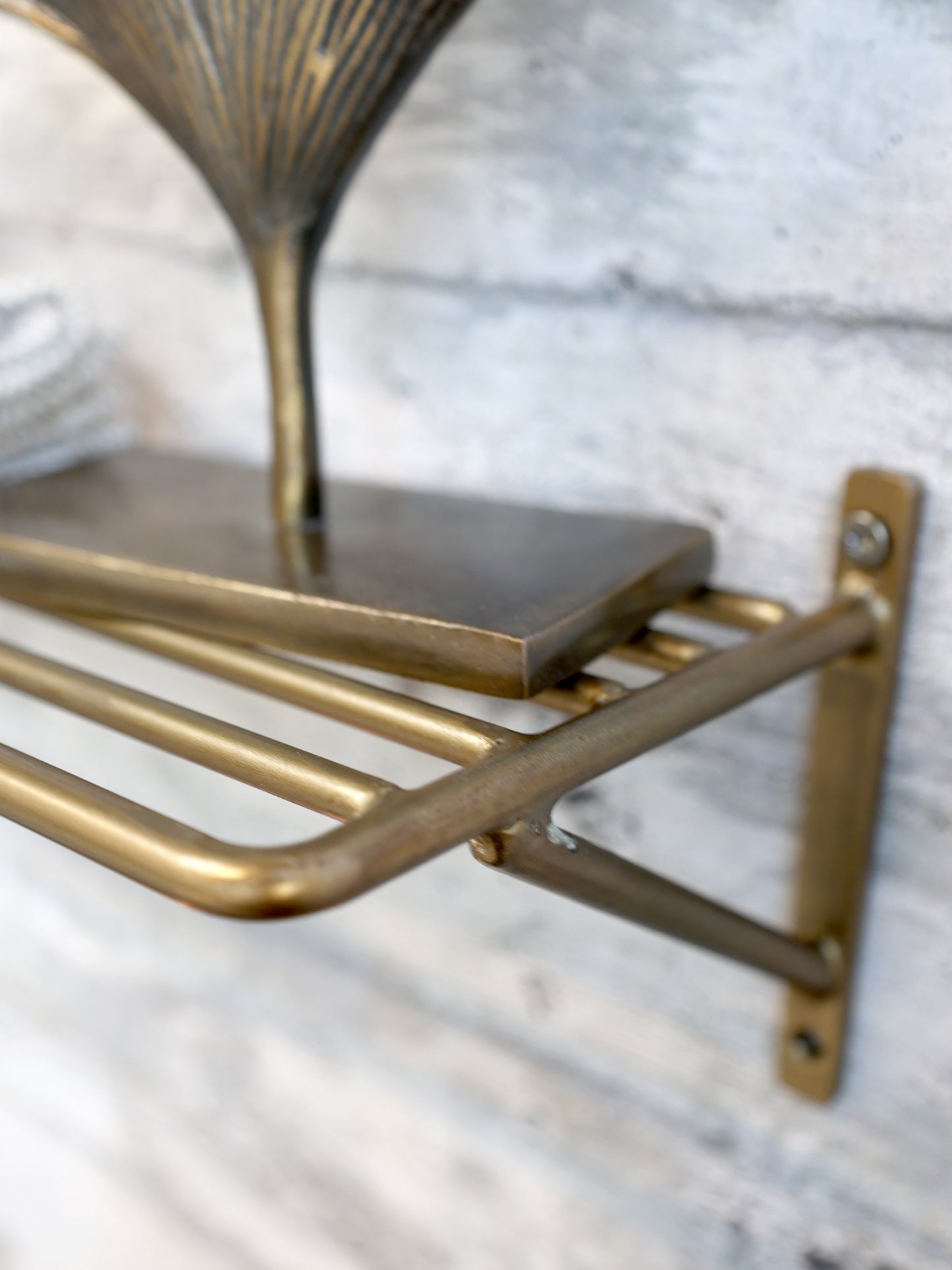 Brass shelf bracket on a marble wall