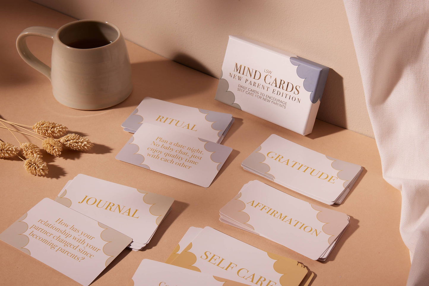 Set of cards on a table with a mug and dried plants