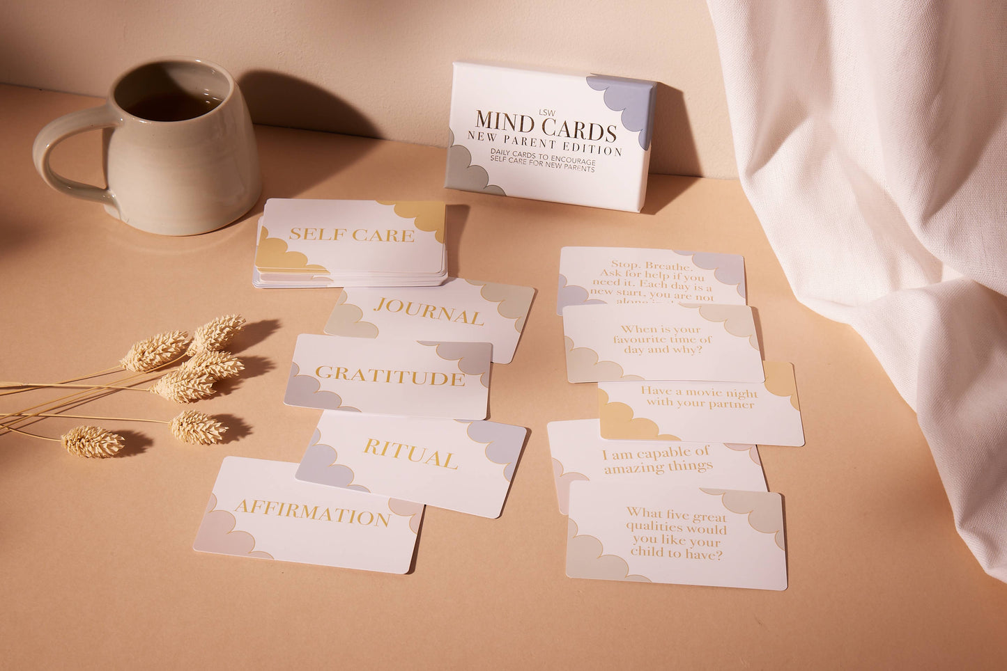 Set of 'Mind Cards' on a beige surface with a mug and dried flowers.