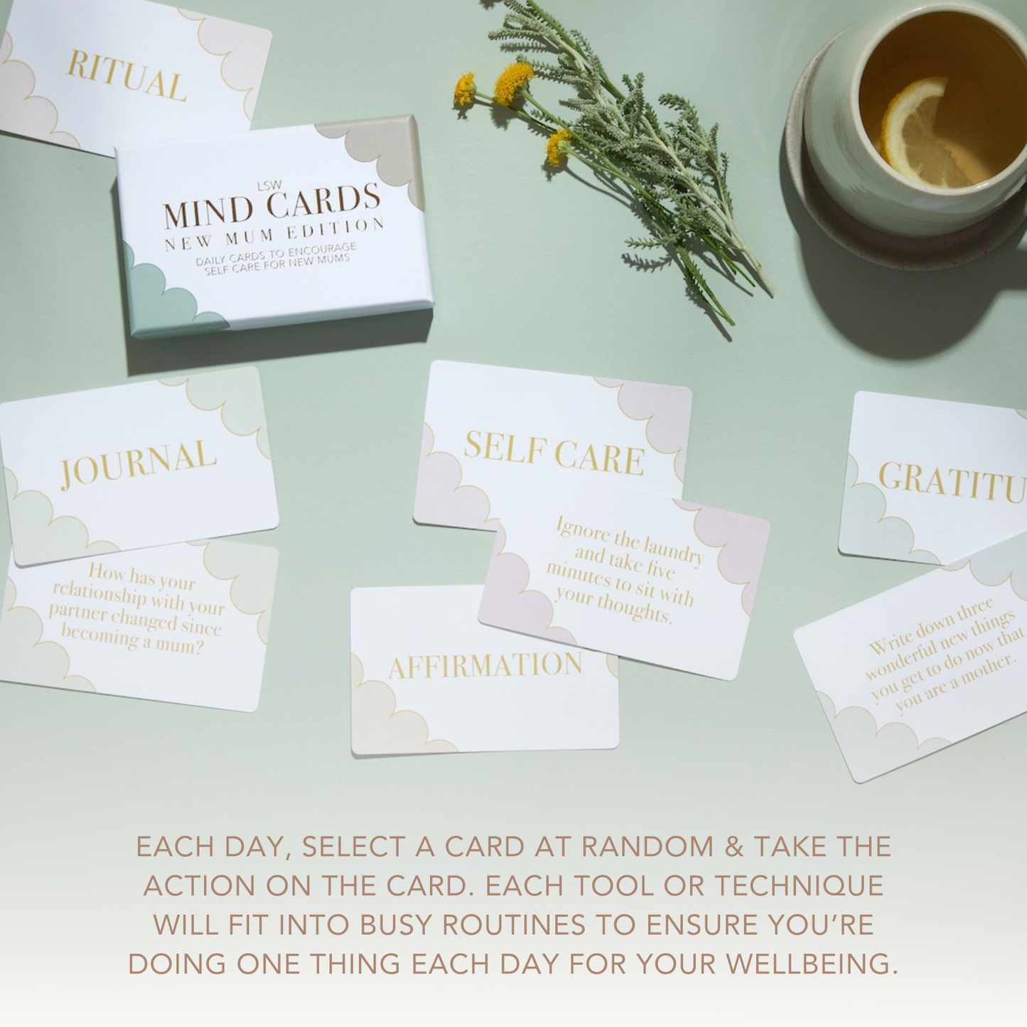 Set of cards with motivational phrases on a light green surface with a cup and flowers.