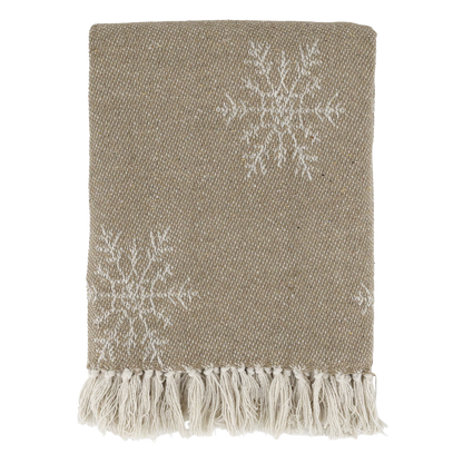 Textured beige throw blanket with white snowflake patterns and fringes on a white background