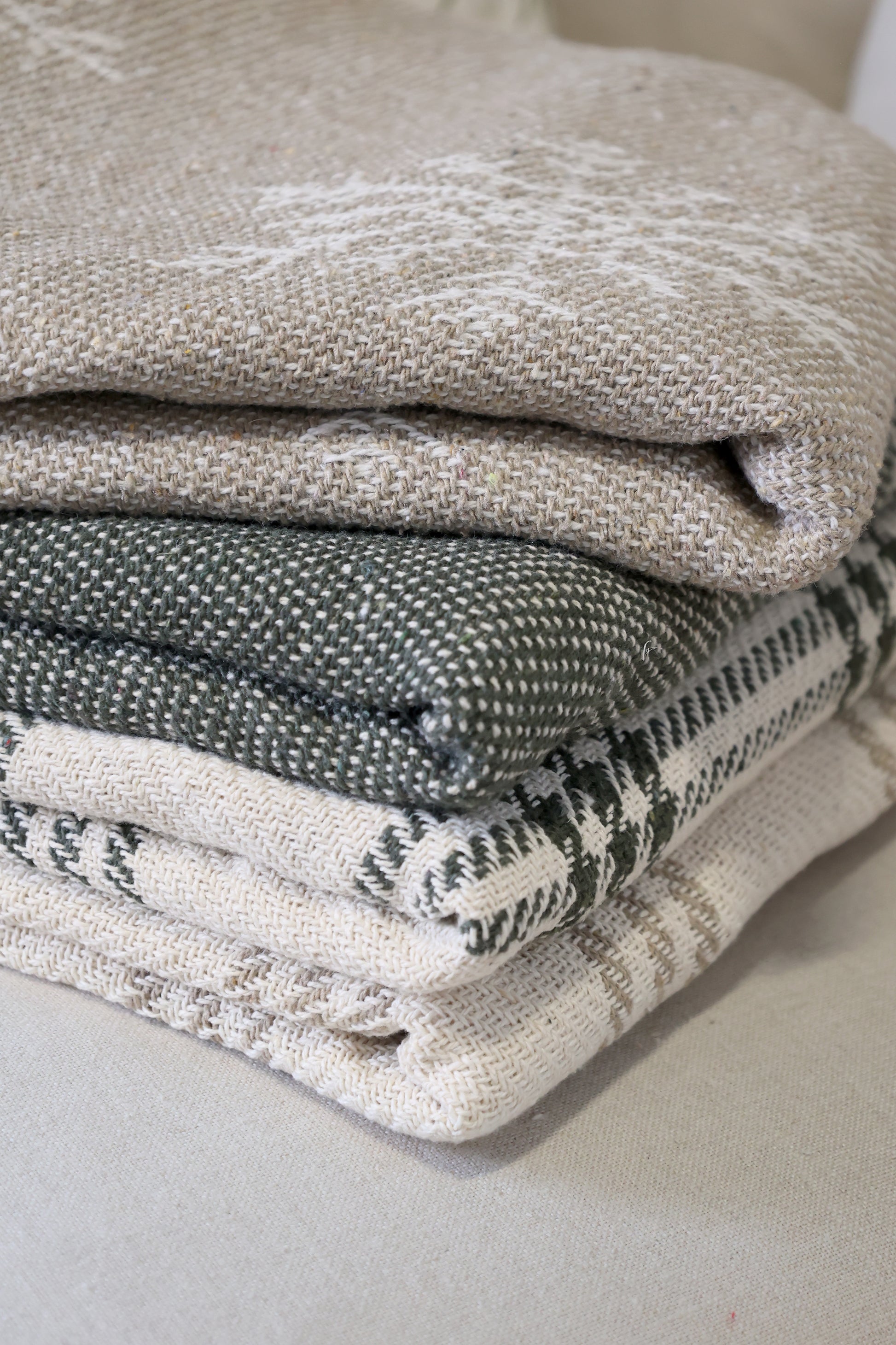 Stack of folded textured fabric pieces on a neutral background