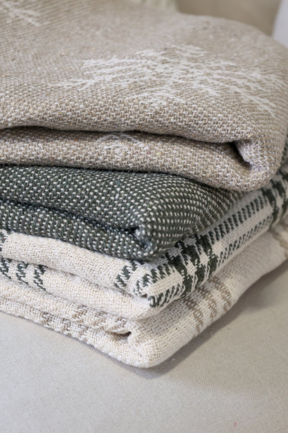 Stack of folded textured fabric pieces on a neutral background