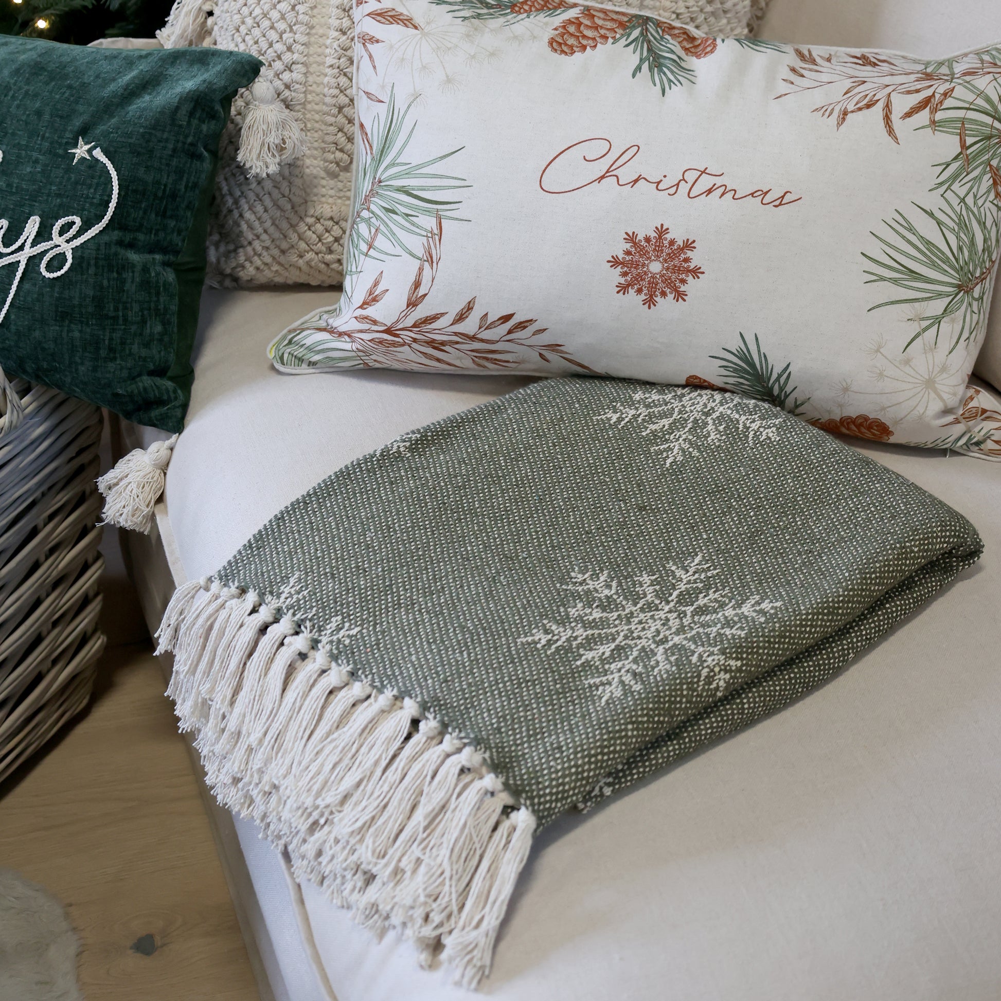 Decorative pillows with Christmas-themed designs on a couch.