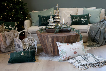 Living room with Christmas decorations including a tree, pillows, and a coffee table.