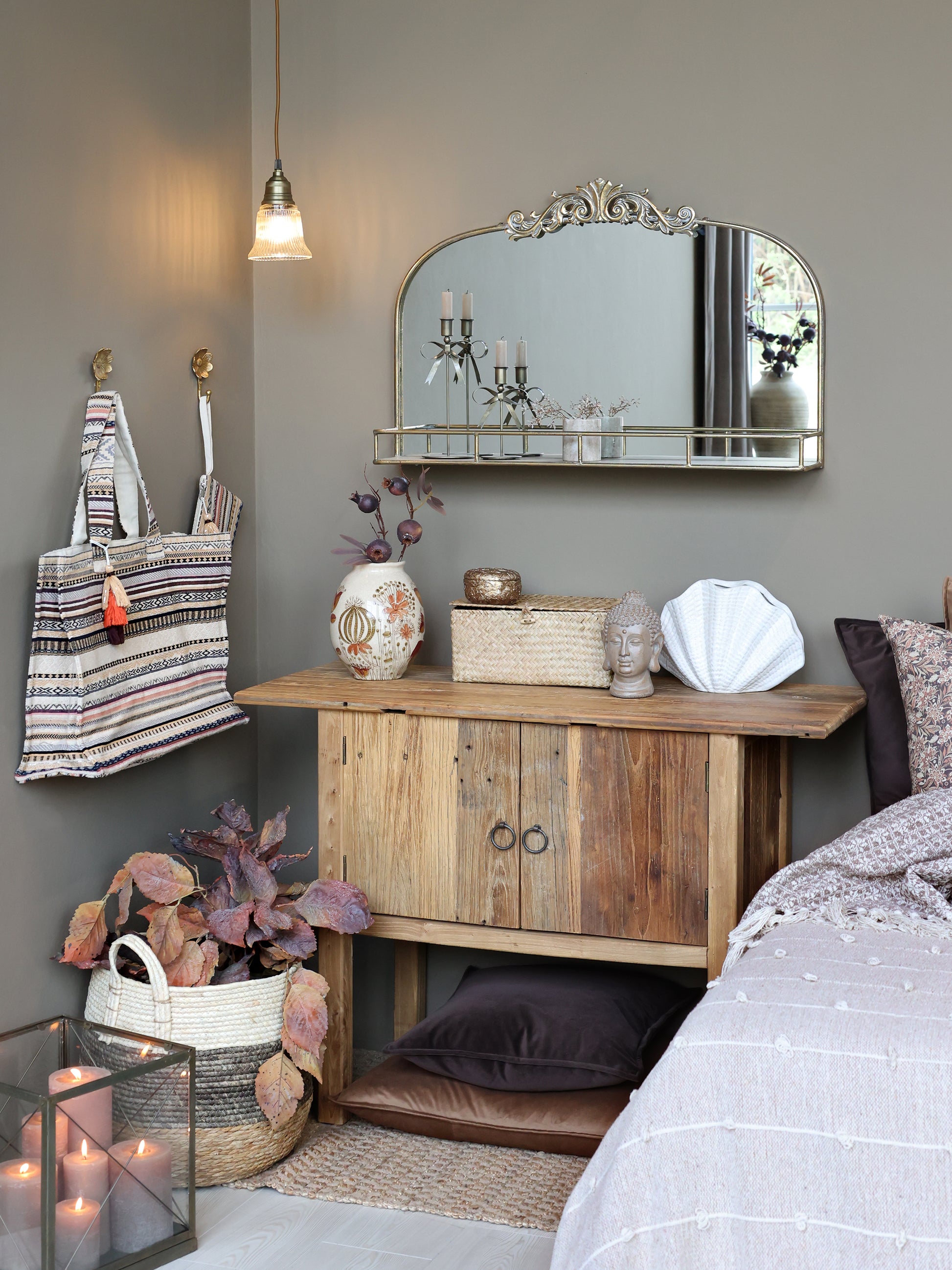 Nursery room with wooden dresser, mirror, and decorative items.