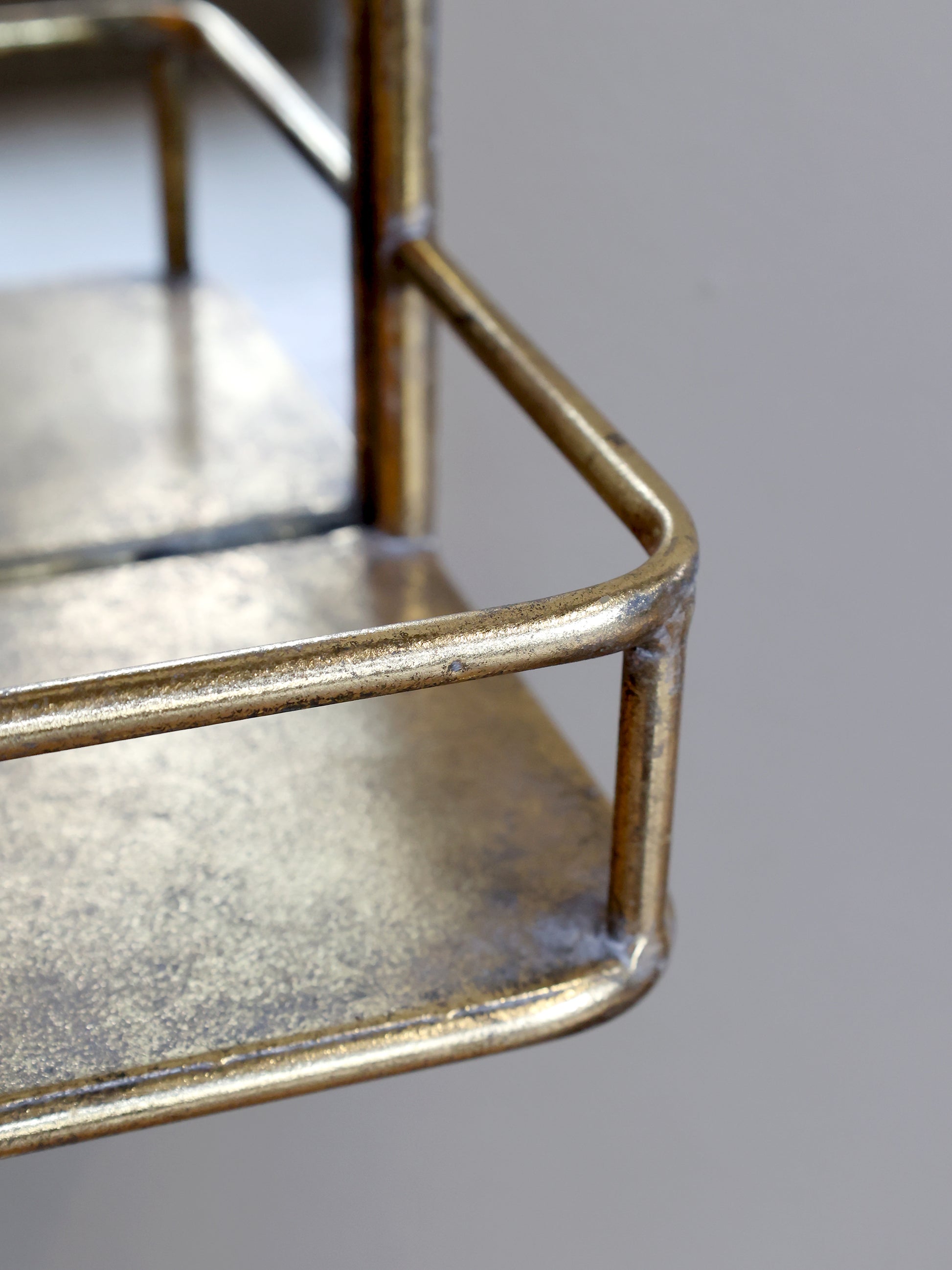 Close-up of a metallic shelf with a reflective surface on a gray background