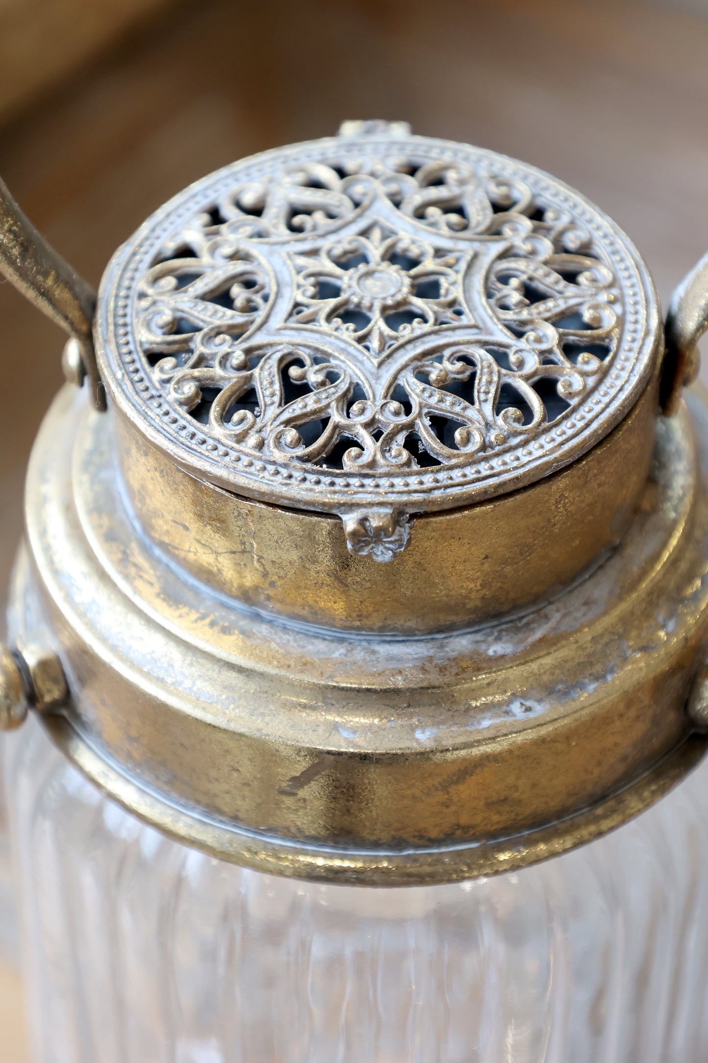 Decorative lantern with intricate metal top and glass body