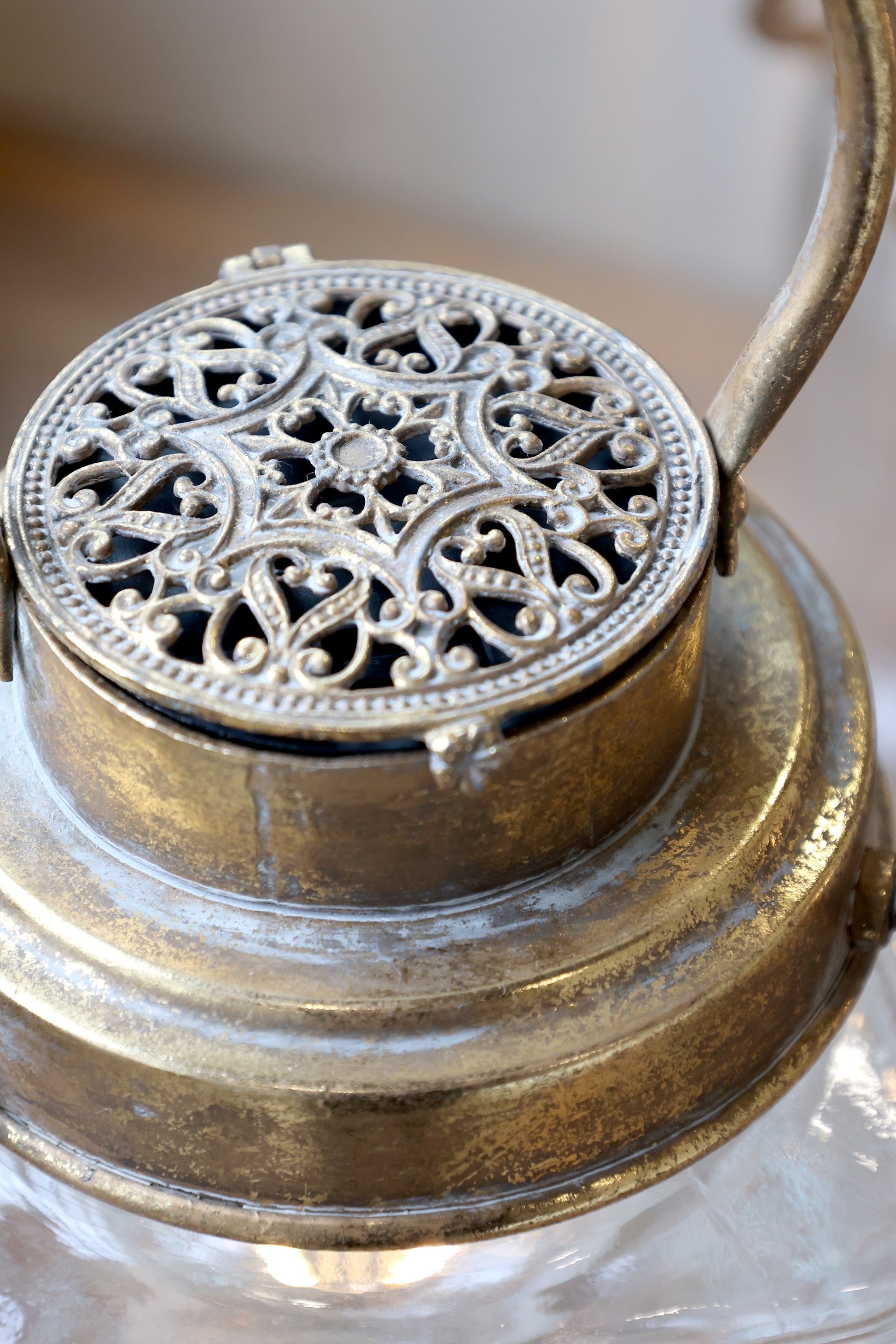 Decorative metal lantern with intricate design on a neutral background