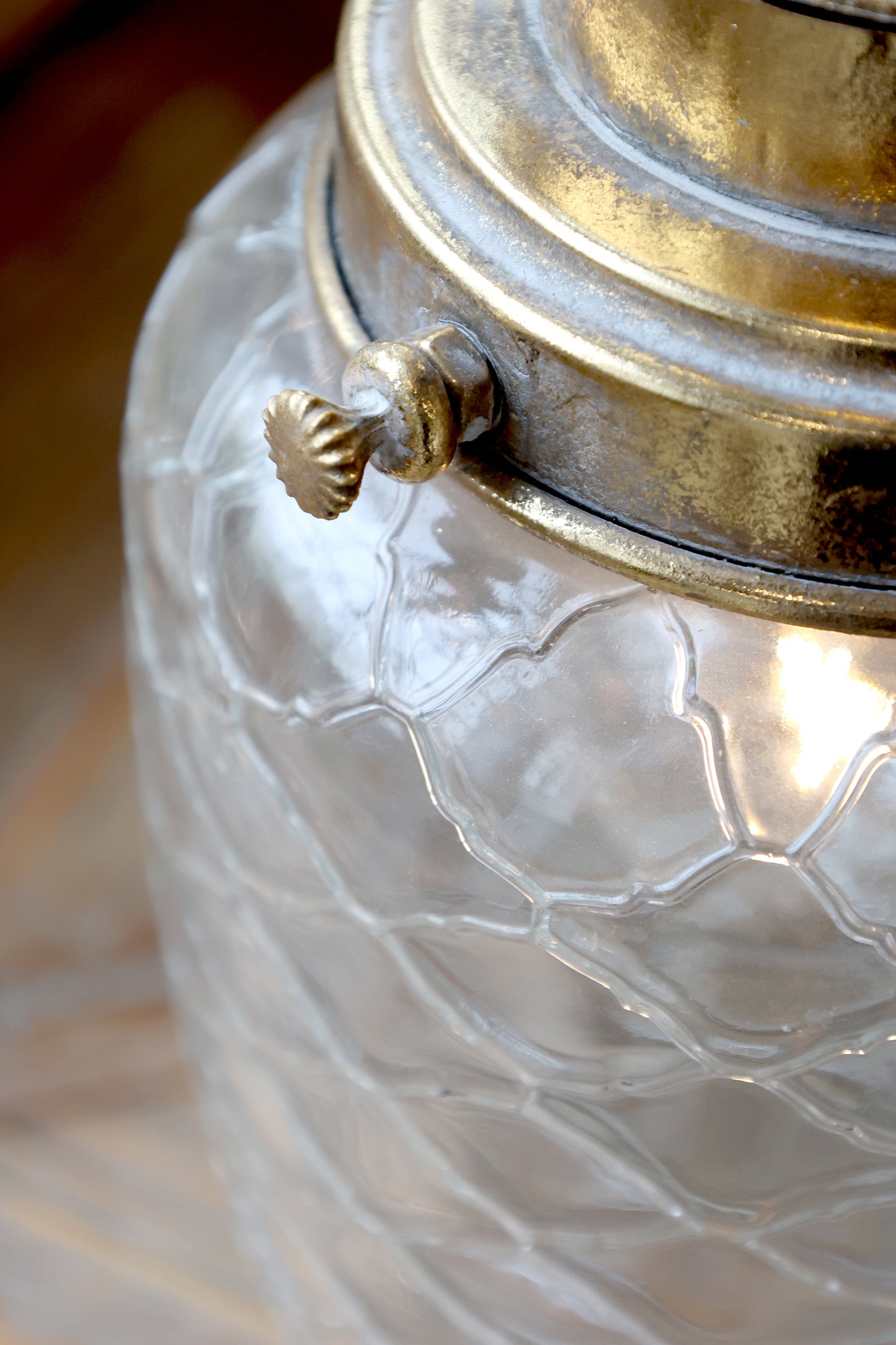 Close-up of a textured glass container with a metallic lid.