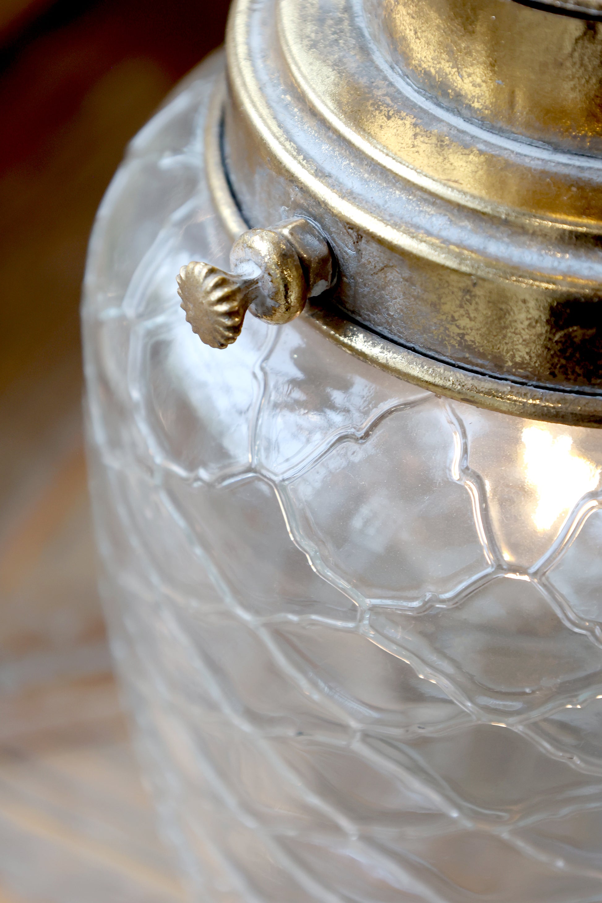 Close-up of a textured glass container with a metallic lid.