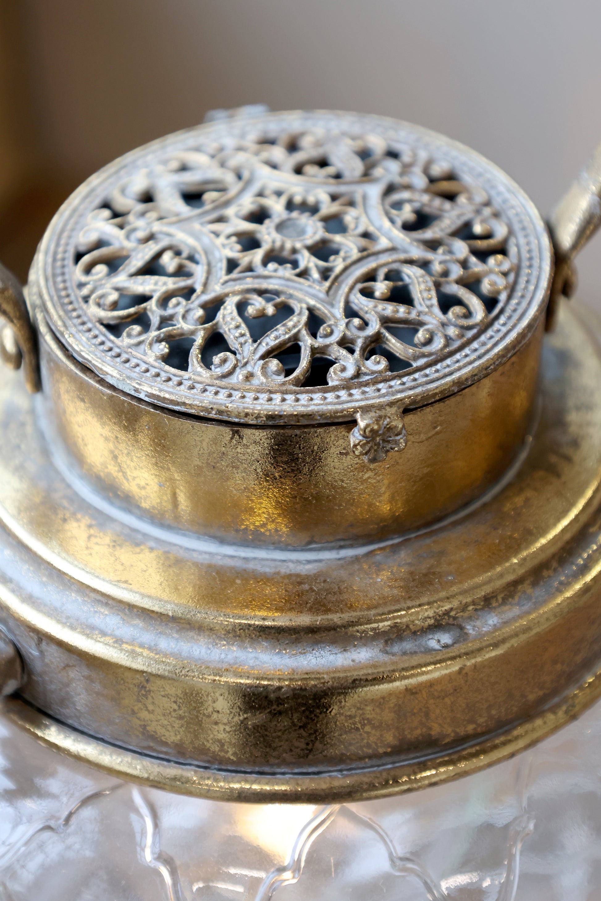 Decorative metal lantern with intricate design on a neutral background