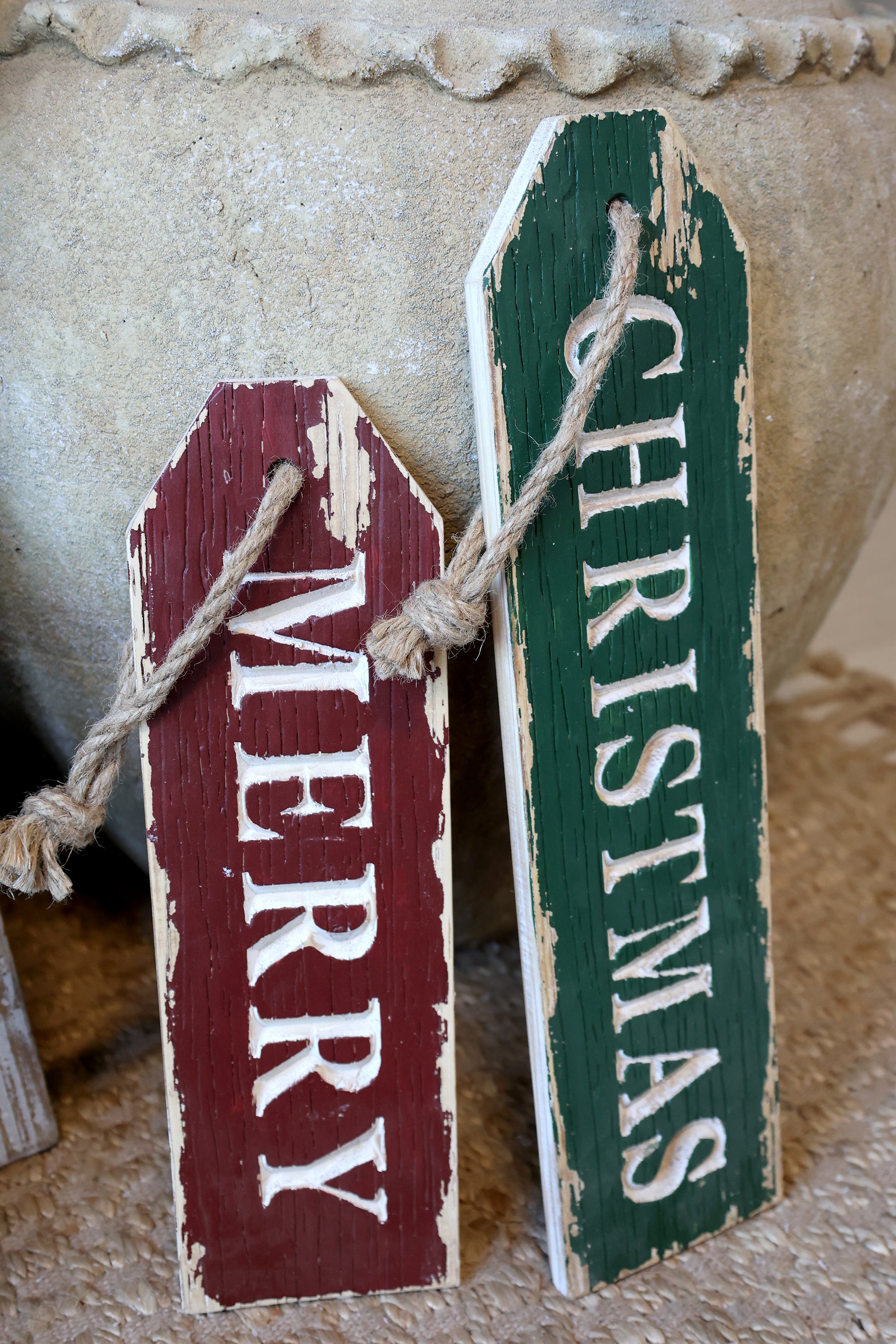Two wooden Christmas signs, one red and one green, with 'Merry' and 'Christmas' text.