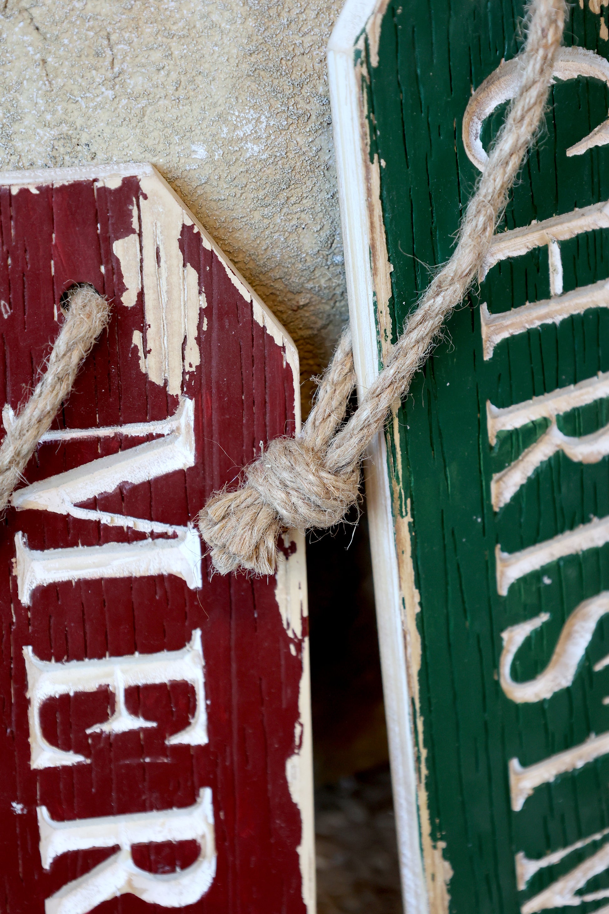 Close-up of wooden signs with 'Merry Christmas' text, tied together with twine.