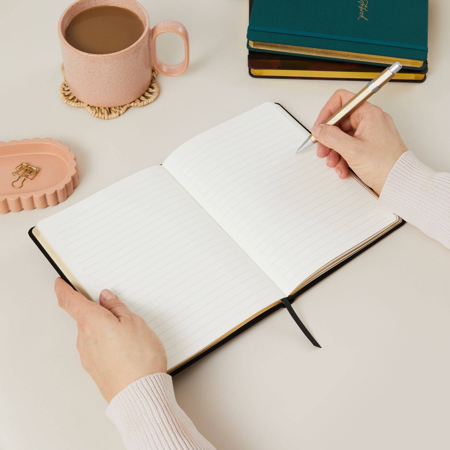 Blush and Gold Black notebook with gold text on a white surface with decorative elements. Generosa Home