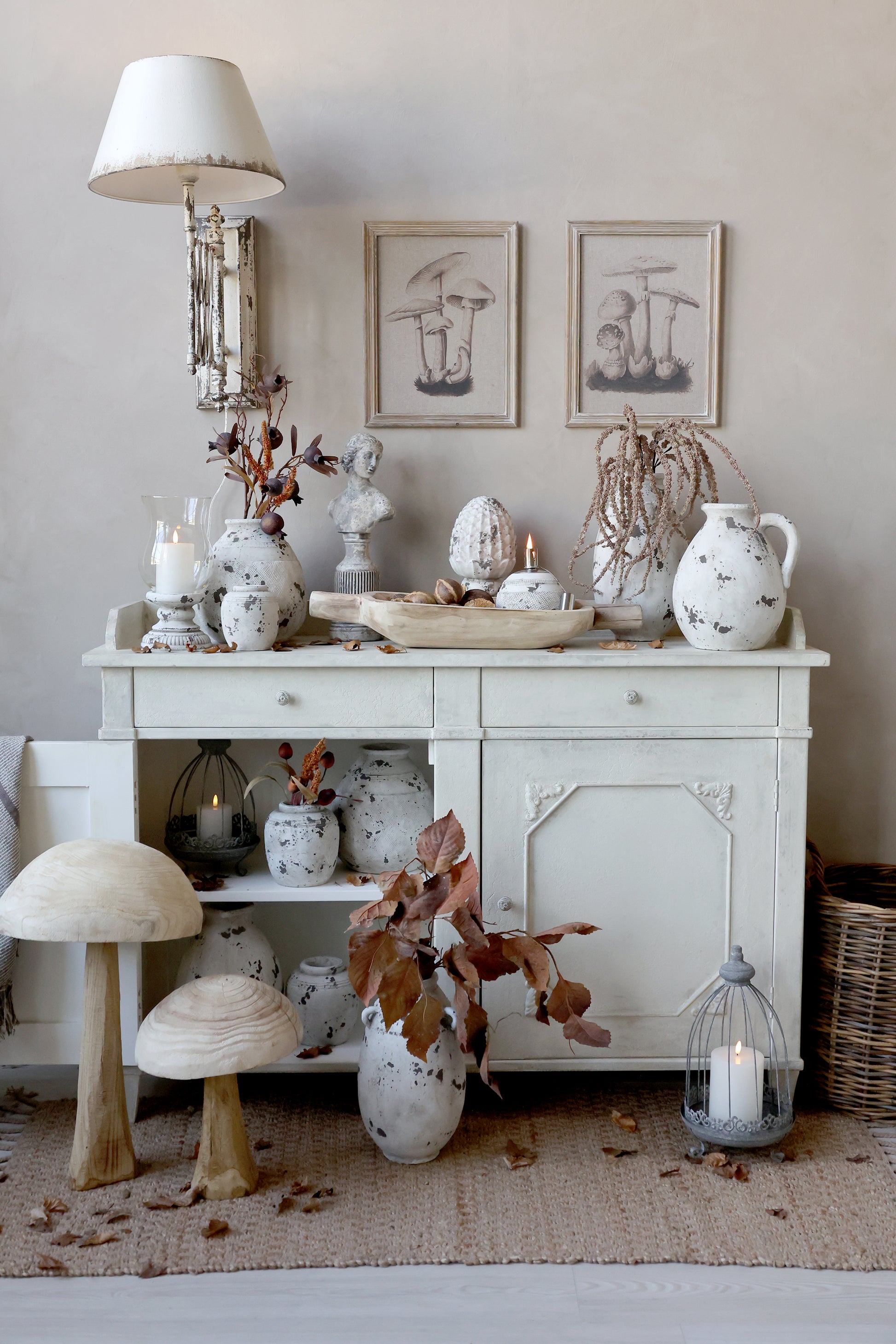 Decorative interior with a white sideboard, vases, and candles on a neutral background