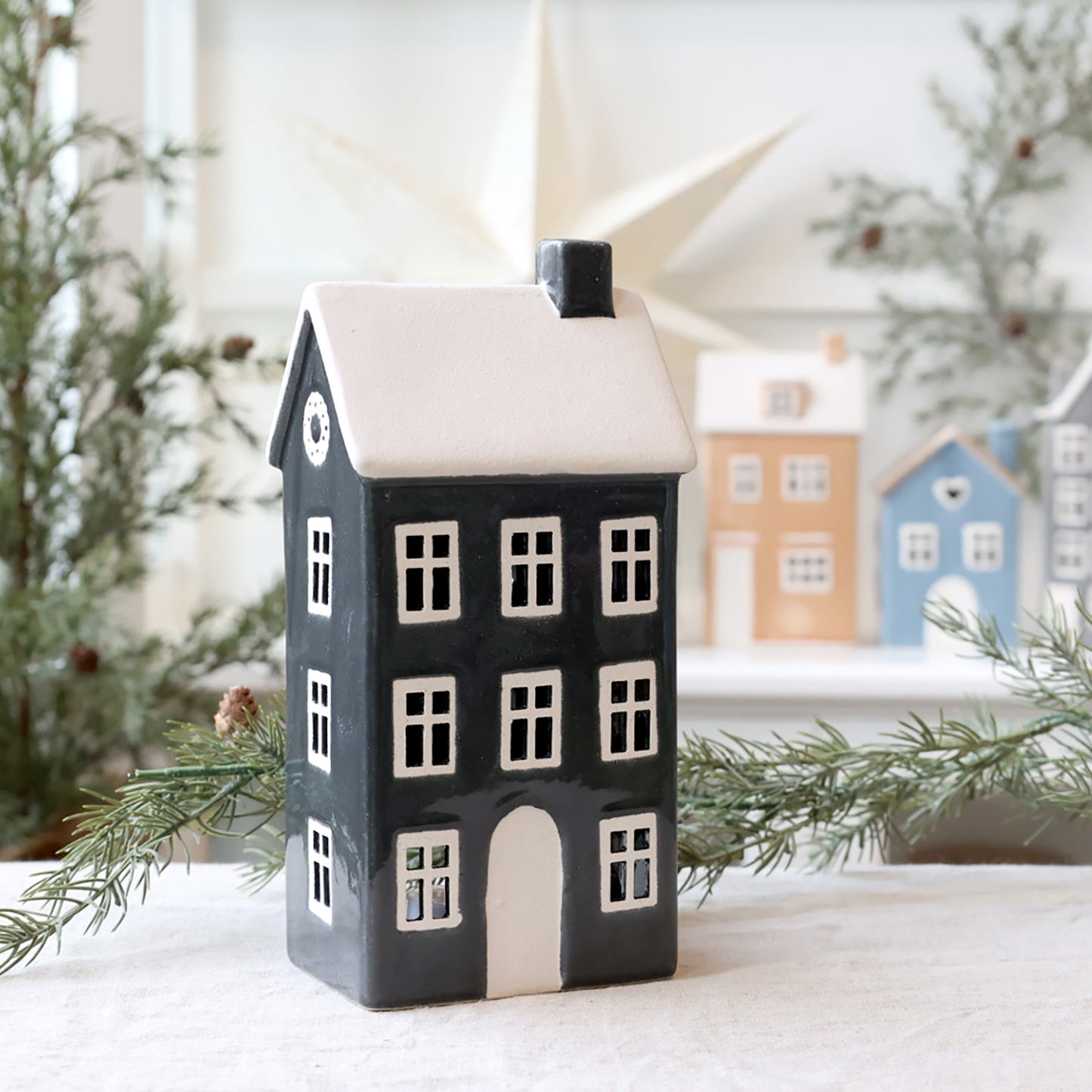 Decorative house-shaped lantern with a snowy background