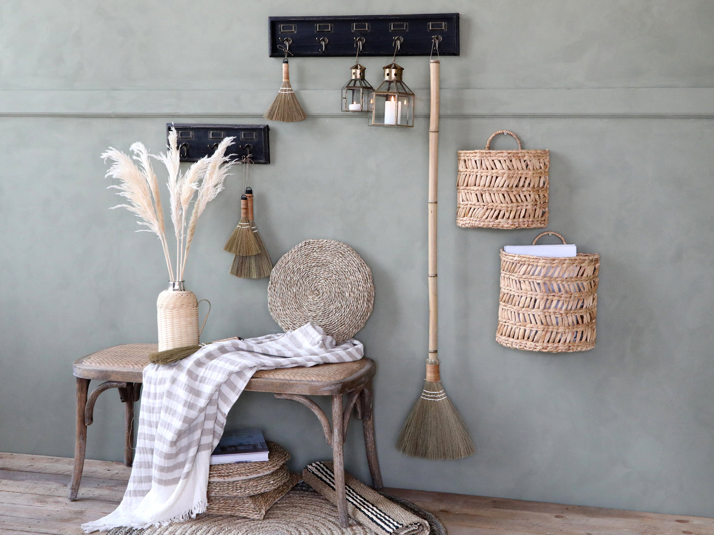 Nautical-themed decor with hooks, lanterns, and baskets against a gray wall.