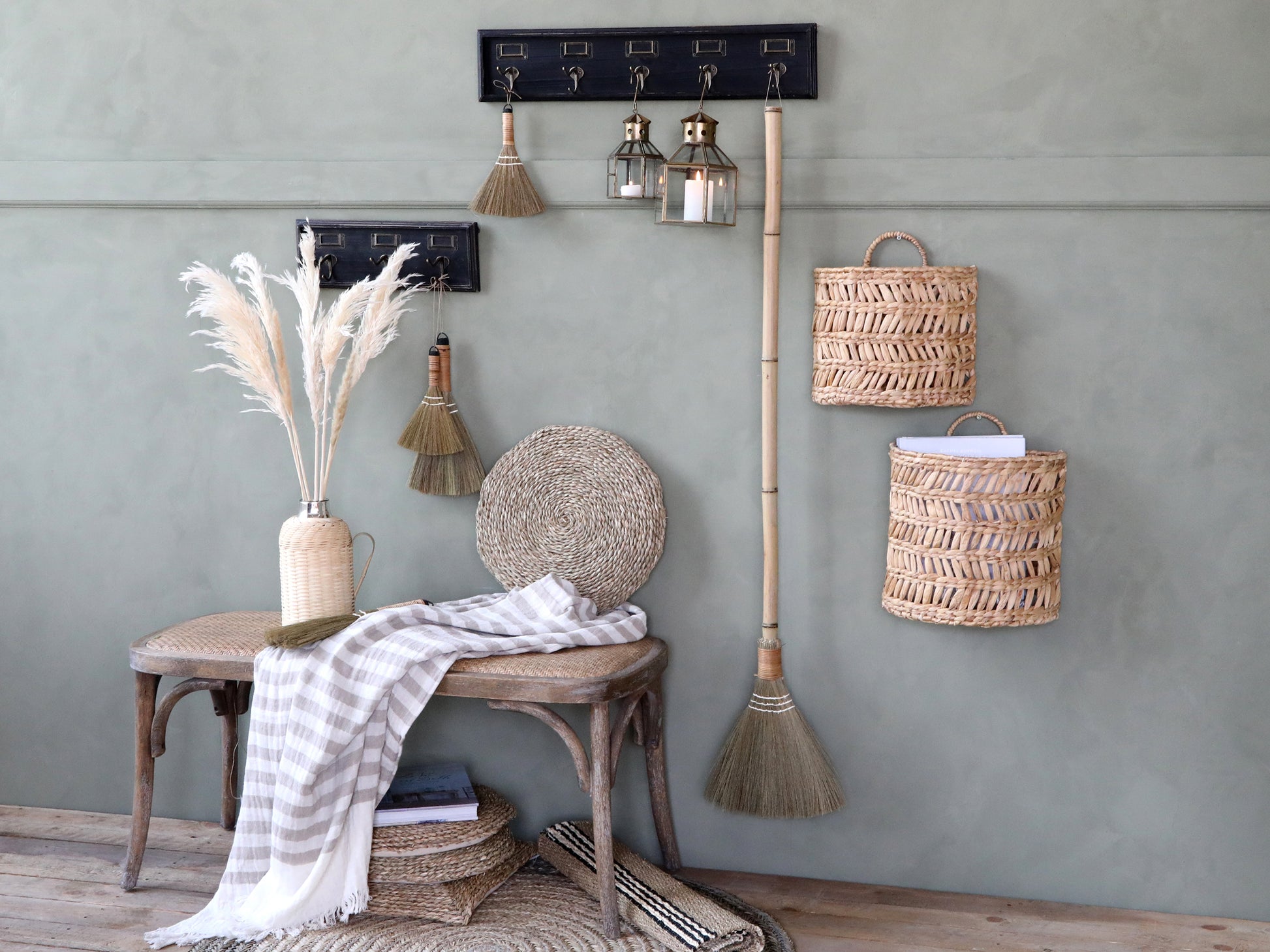 Nautical-themed decor with hooks, lanterns, and baskets against a gray wall.