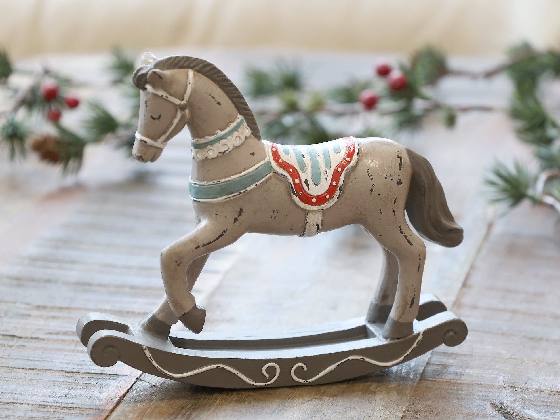 Decorative rocking horse on a wooden surface with a festive background