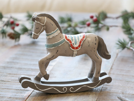 Decorative rocking horse on a wooden surface with a festive background