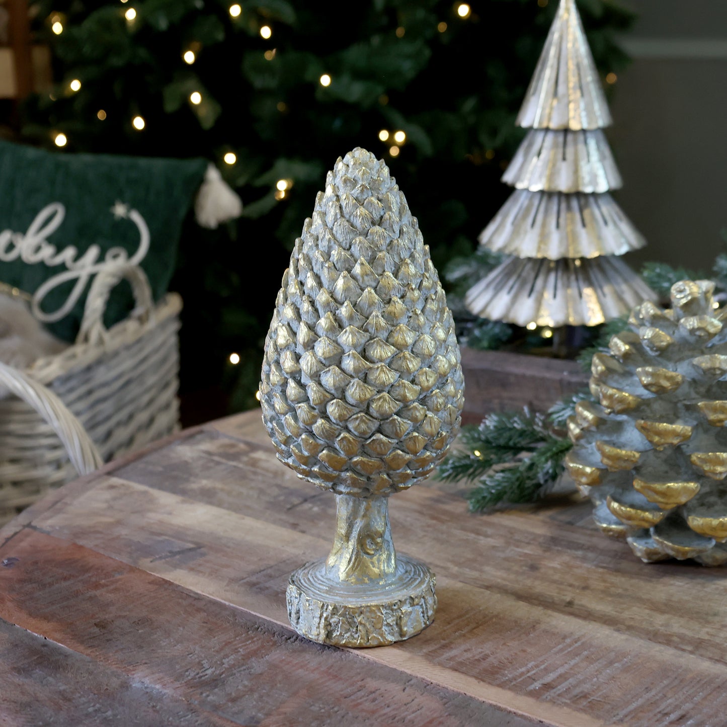 Decorative pine cone on a wooden surface with Christmas decorations in the background