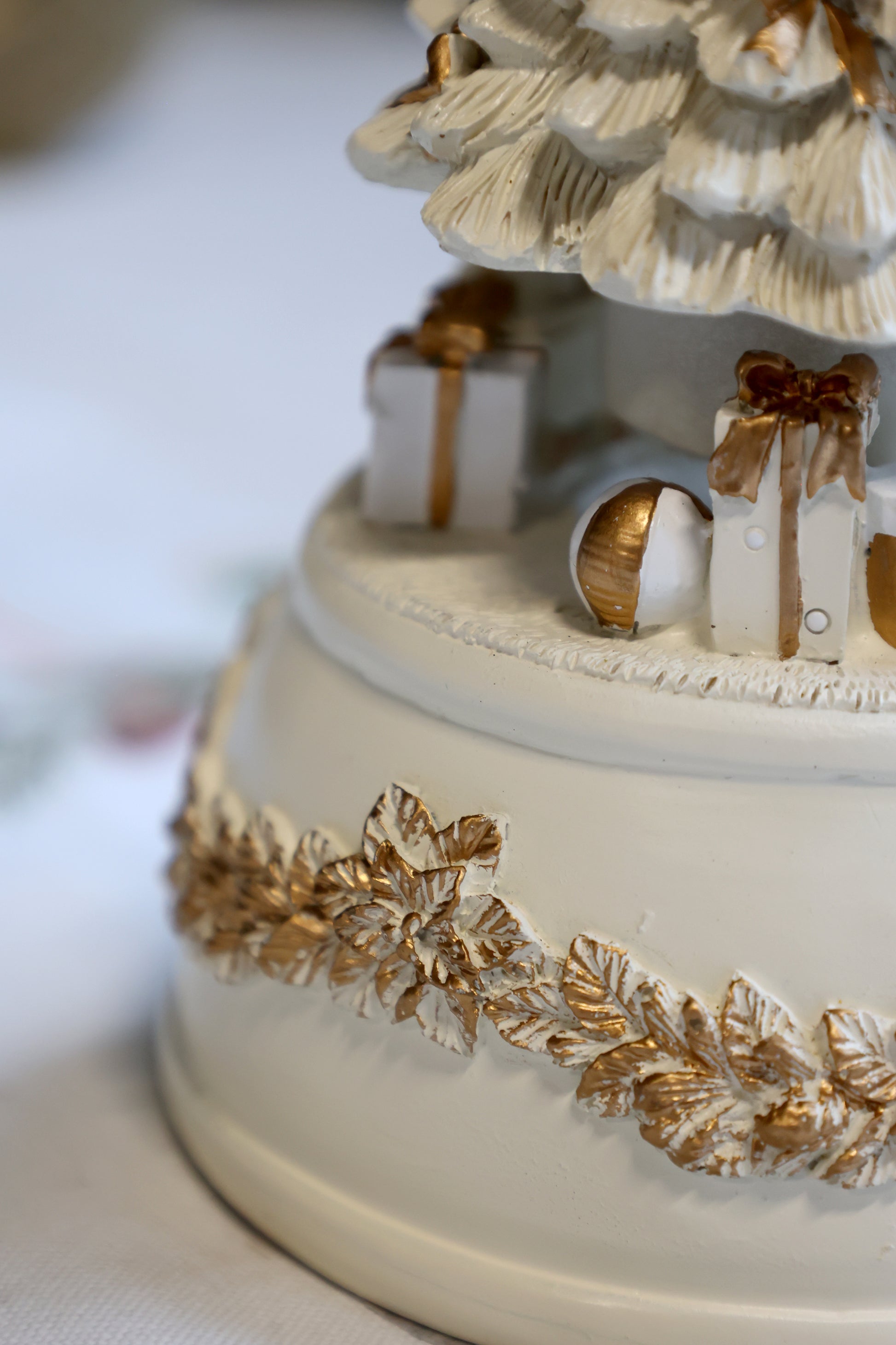 Decorative cake with gold accents and a Christmas tree design on a white background