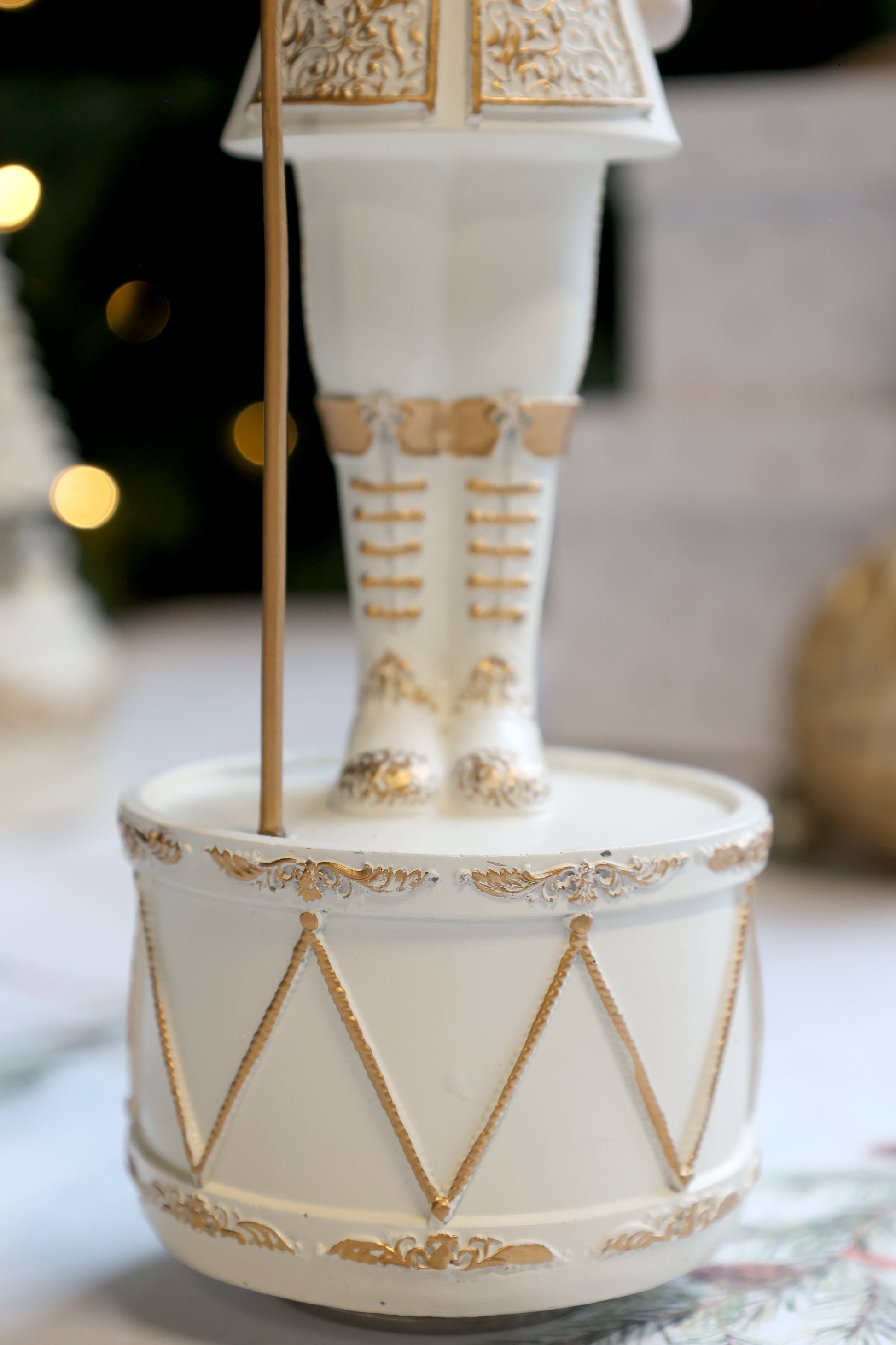 Decorative white and gold figurine on a stand with a blurred background