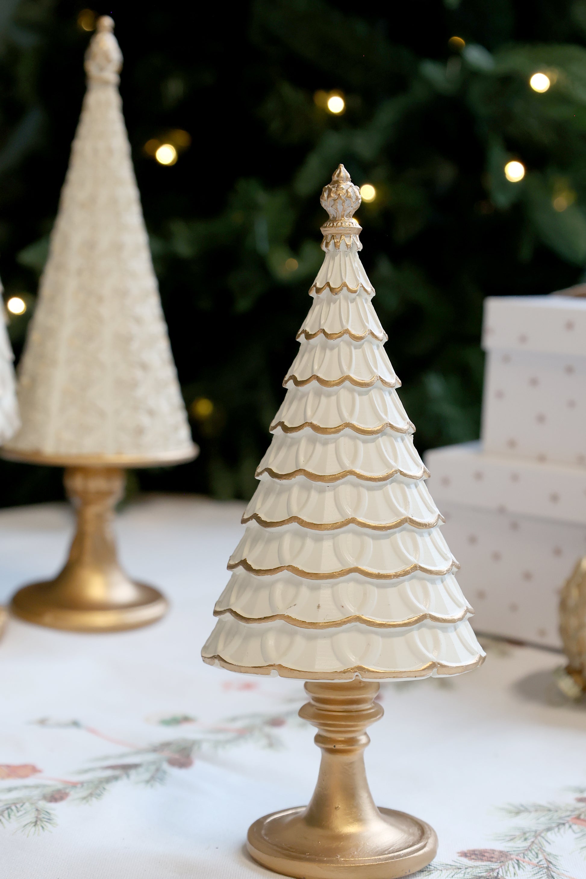 Decorative Christmas tree with gold base on a floral tablecloth