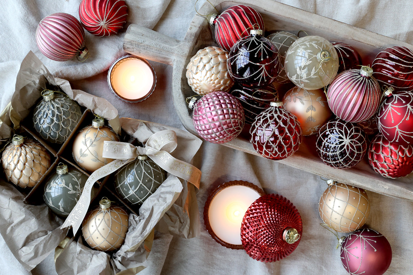 Decorative Christmas ornaments with candles on a textured surface. Generosa Home