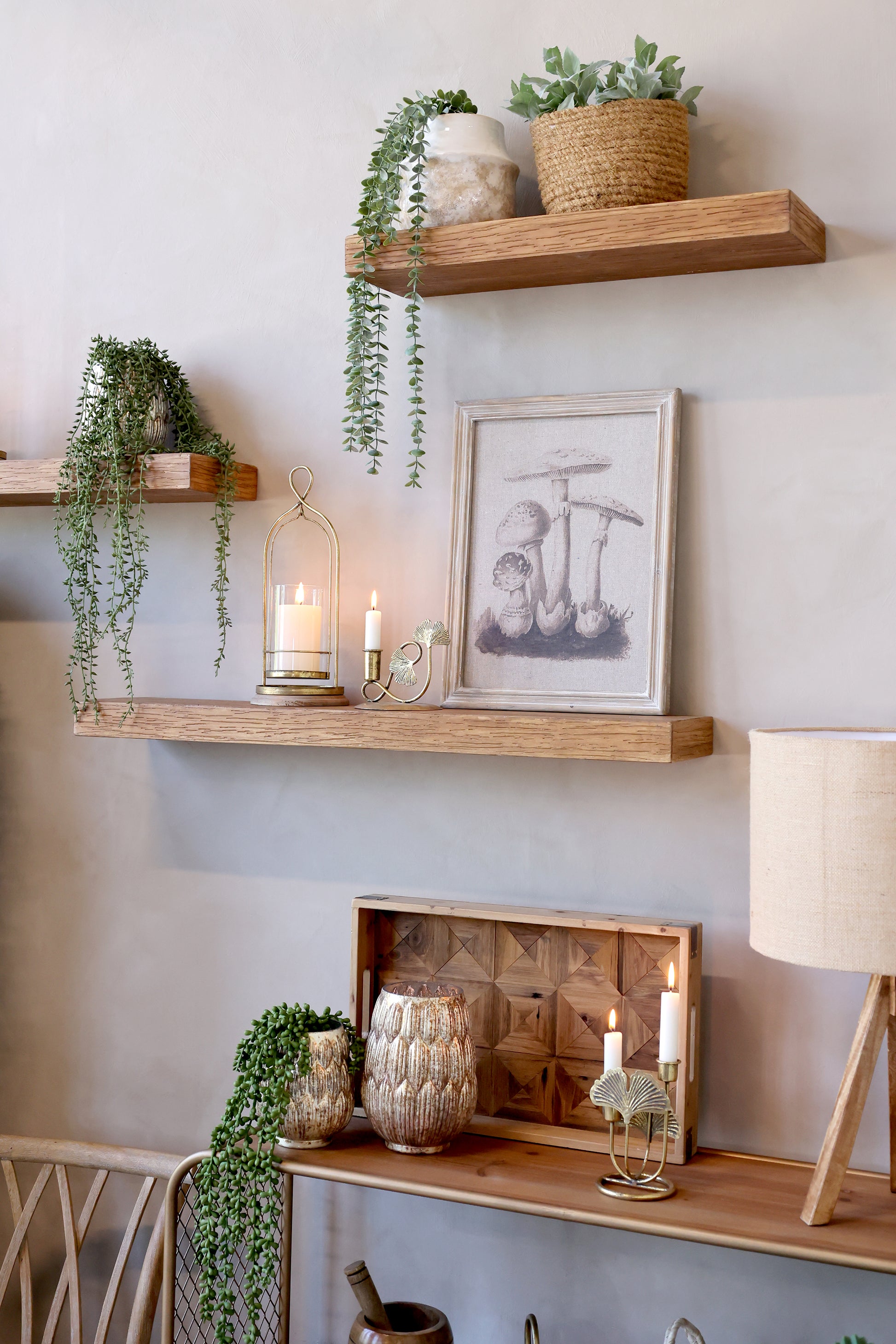 Nestled nook with wooden shelves, plants, and decor against a light gray wall.