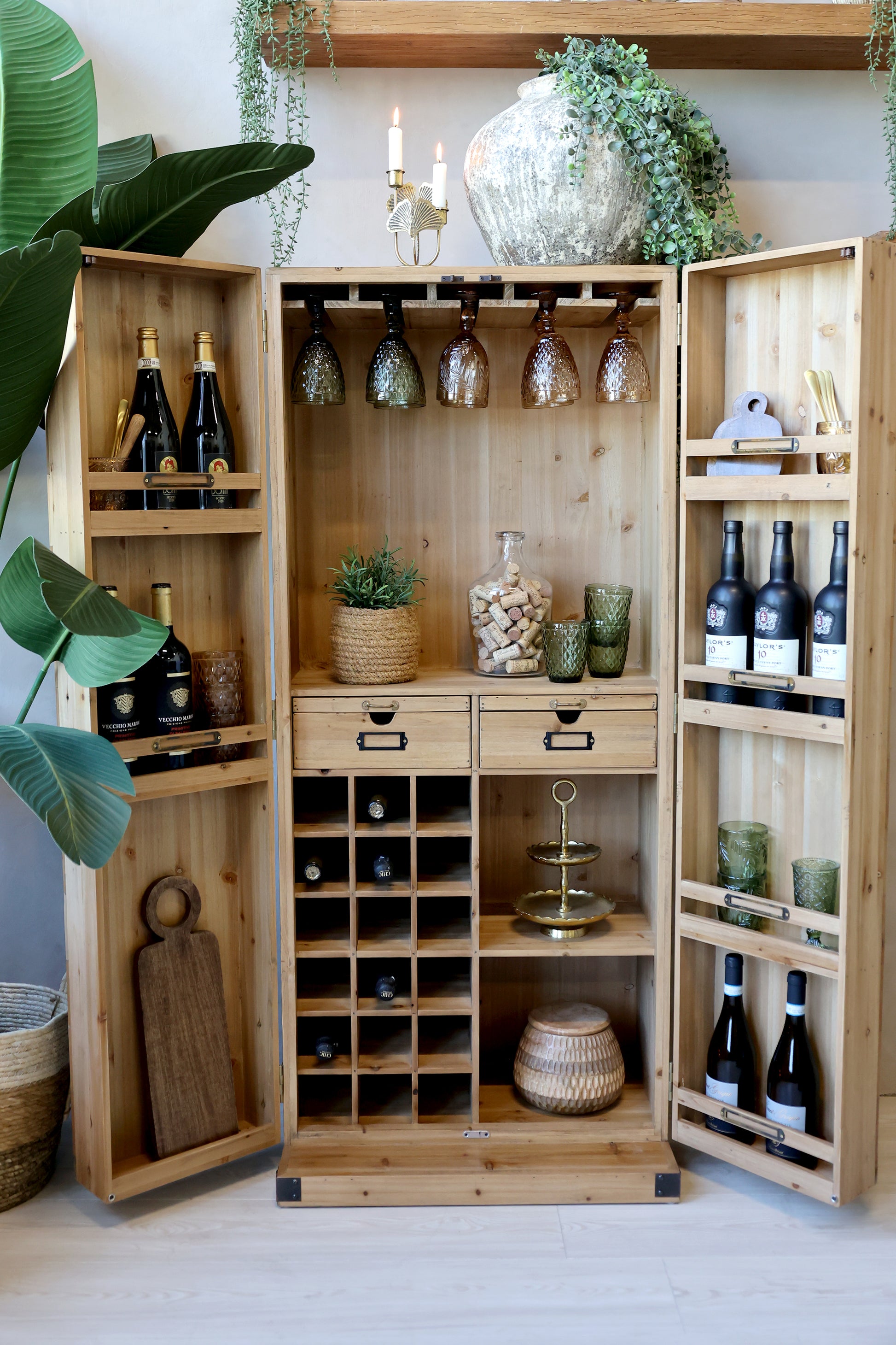 Wooden wine cabinet with bottles, glasses, and decor in a home setting