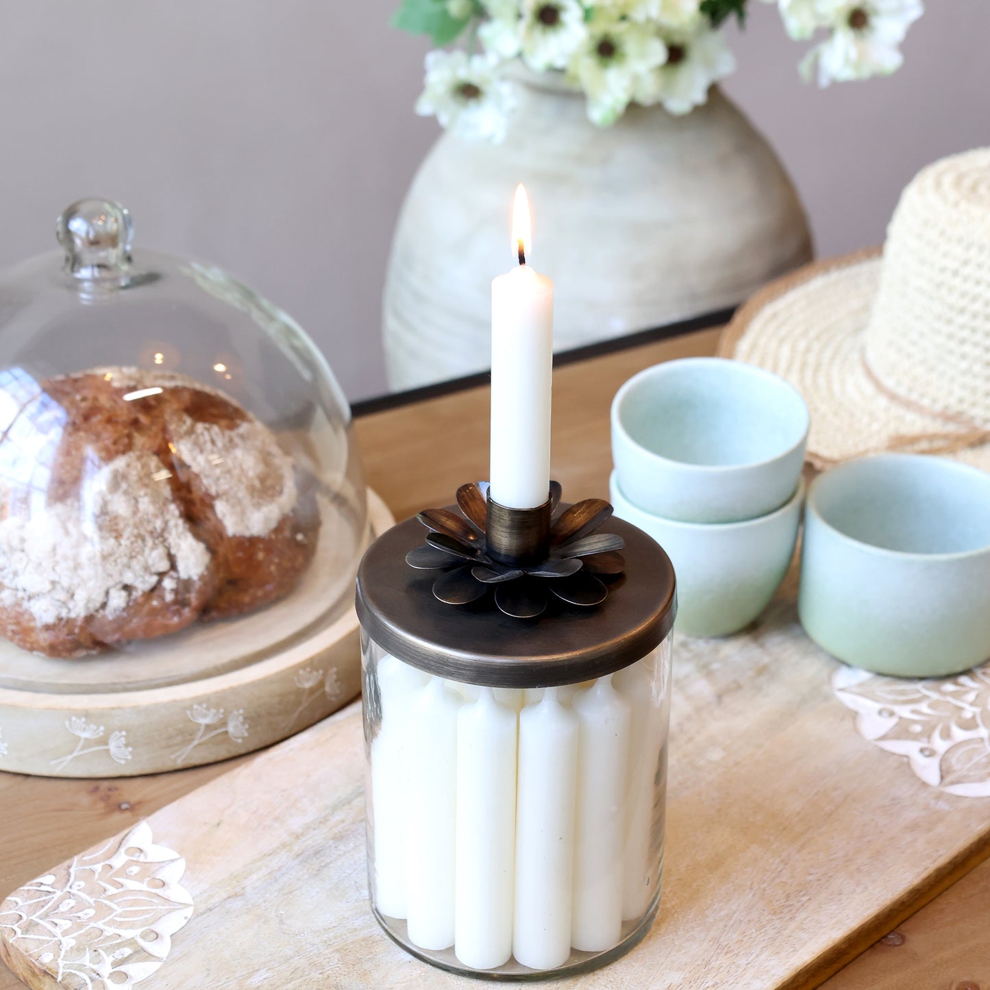 Candle holder with white candles on a table with decorative items