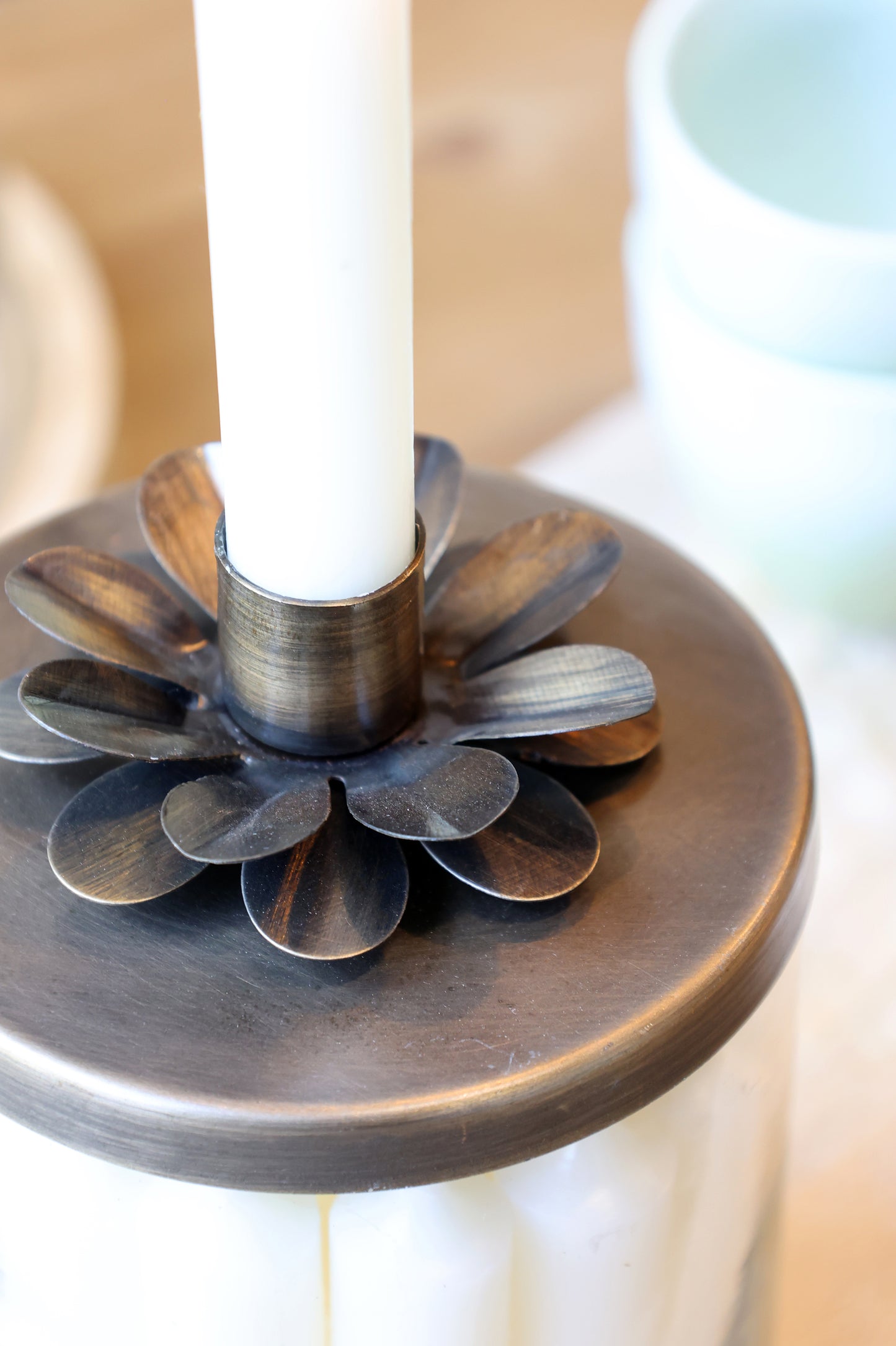 Decorative candle holder with a white candle on a blurred background