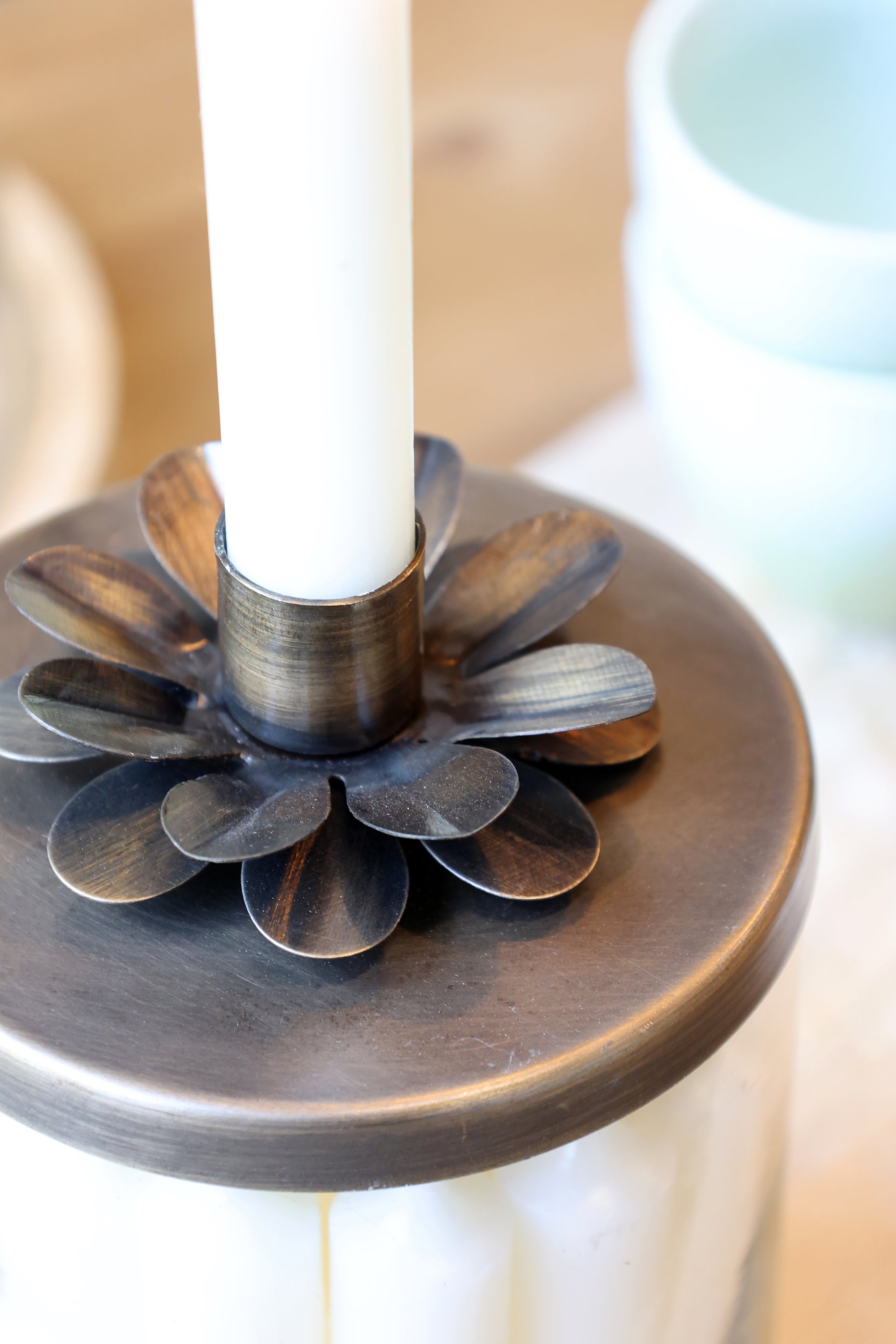 Decorative candle holder with a white candle on a blurred background
