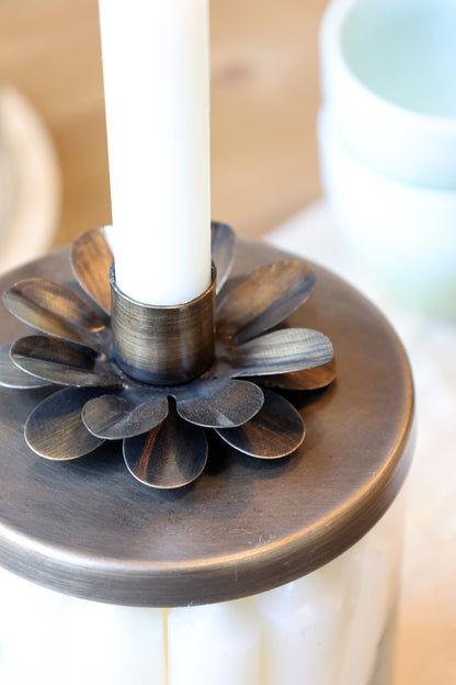 Decorative candle holder with a white candle on a blurred background