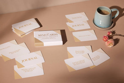 Journals and cards on a table with a mug and flowers