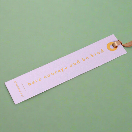 Open book with a purple bookmark that says 'Have courage and be kind'.