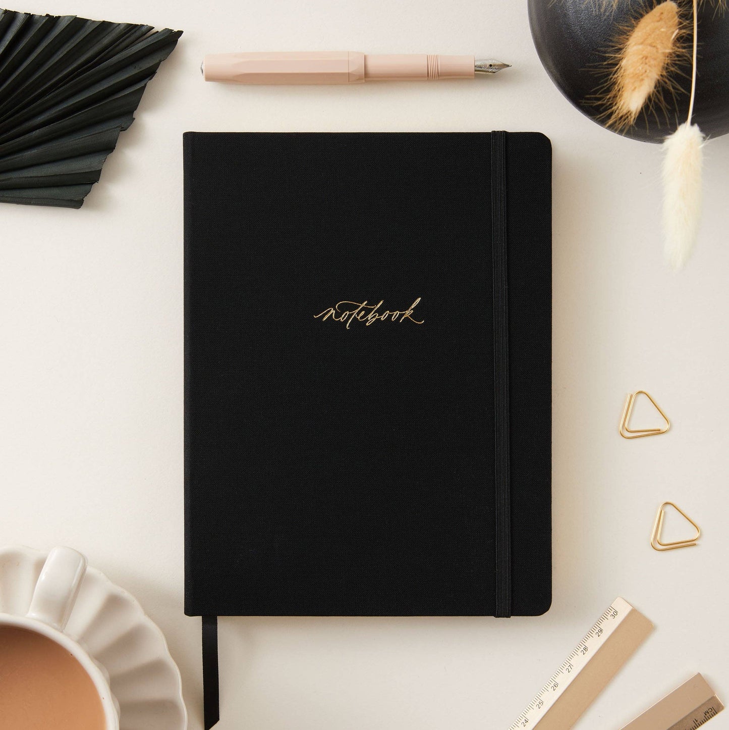Blush and Gold Black notebook with gold text on a white surface with decorative elements. Generosa Home