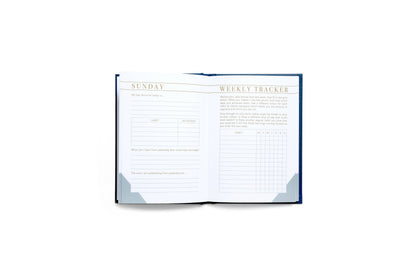 Open weekly tracker notebook on a white background